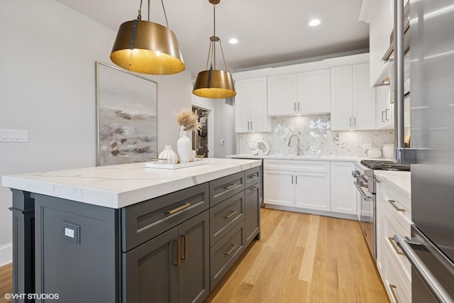514 Hillgrove Ave Unit 303, Western Springs, IL 60558 - kitchen with appliances with stainless steel finishes, gray cabinetry, light wood finished floors, a kitchen island, and decorative backsplash