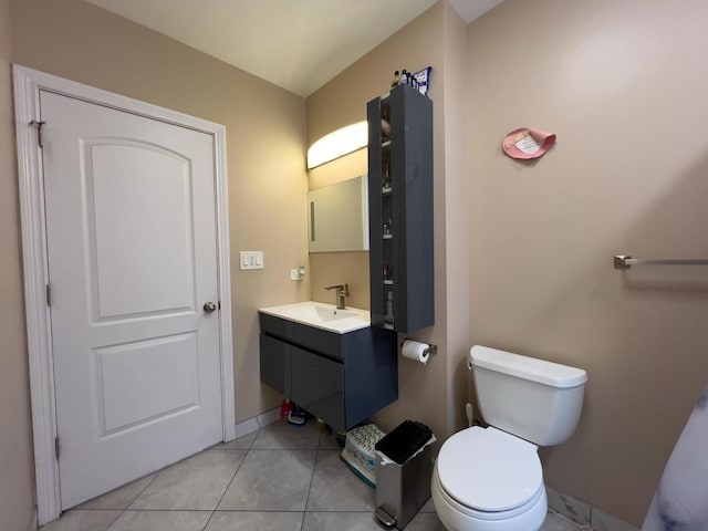 half bathroom with toilet, baseboards, tile patterned flooring, and vanity