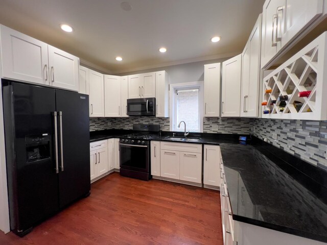 kitchen with a sink, decorative backsplash, range with gas cooktop, and black fridge with ice dispenser