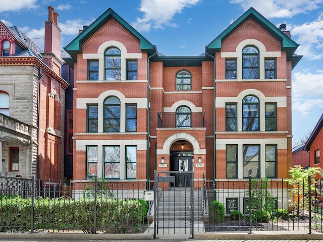 2119 W Evergreen Ave Unit 3W, Chicago, IL 60622 - view of front of house featuring brick siding and a fenced front yard