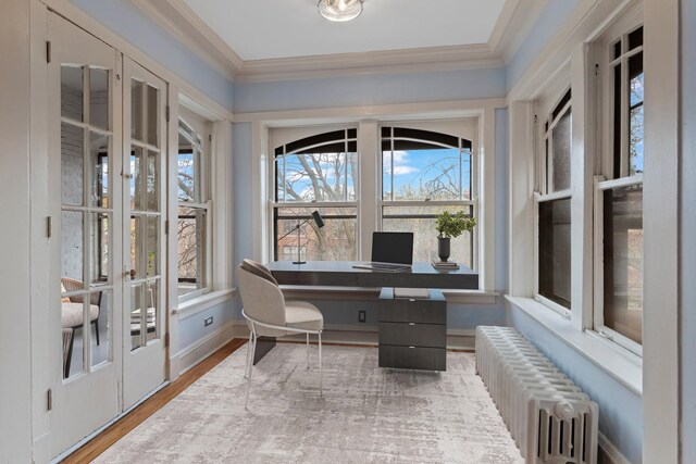 office featuring crown molding, radiator, baseboards, and wood finished floors