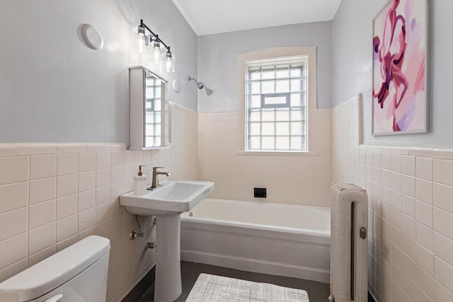 full bath featuring radiator, wainscoting, toilet, and tile walls
