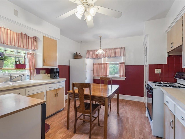 kitchen featuring light countertops, a ceiling fan, plenty of natural light, and gas range