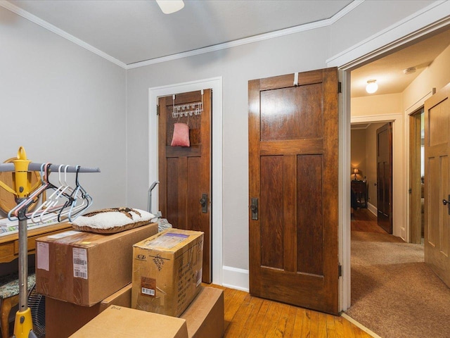 interior space featuring crown molding, baseboards, and hardwood / wood-style floors