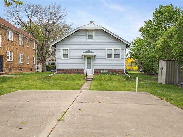 bungalow-style home featuring an outdoor structure, a storage shed, and a front yard