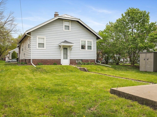 view of front facade featuring a chimney, an outdoor structure, a storage shed, and a front yard