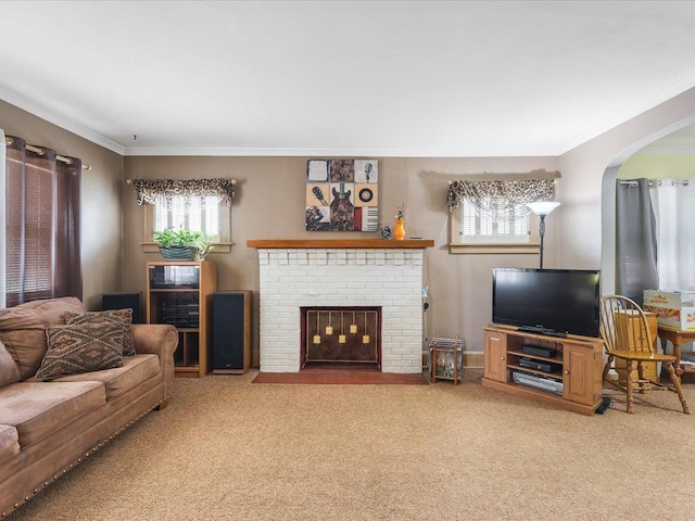 living area with ornamental molding, a brick fireplace, and carpet flooring