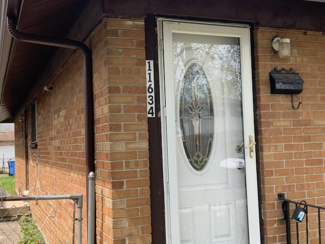 view of exterior entry featuring brick siding
