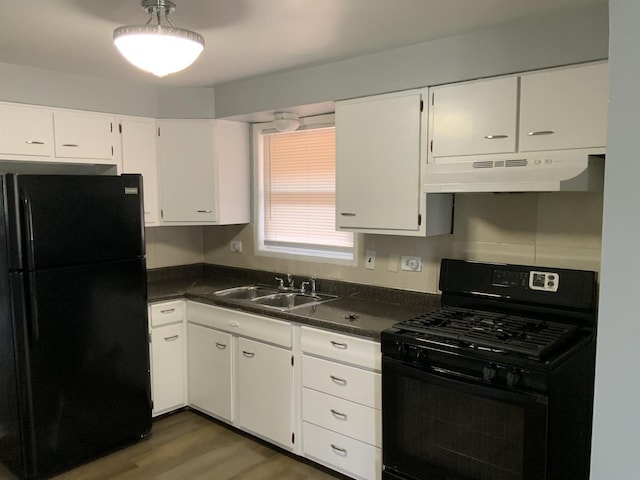 kitchen featuring under cabinet range hood, dark countertops, a sink, and black appliances