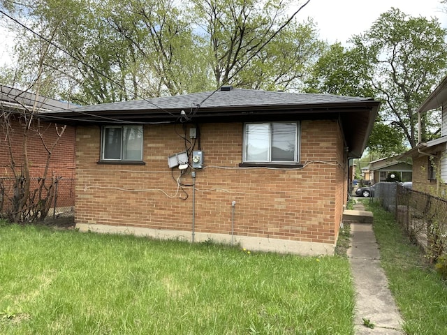view of property exterior featuring brick siding, a shingled roof, and fence