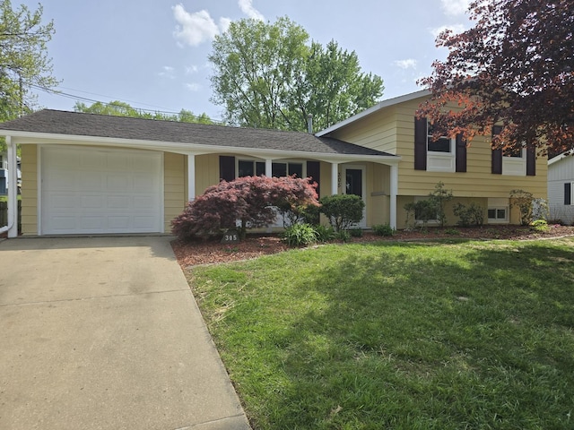 tri-level home with a garage, a front lawn, and concrete driveway