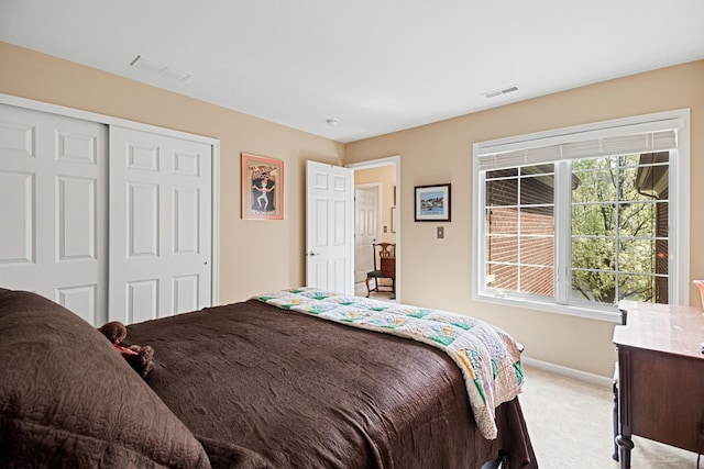 bedroom with light colored carpet, baseboards, visible vents, and a closet