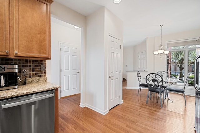 kitchen featuring an inviting chandelier, tasteful backsplash, dishwasher, baseboards, and light wood-type flooring