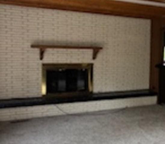 2700 Chariot Ln, Olympia Fields, IL 60461 - unfurnished living room featuring a glass covered fireplace and carpet flooring