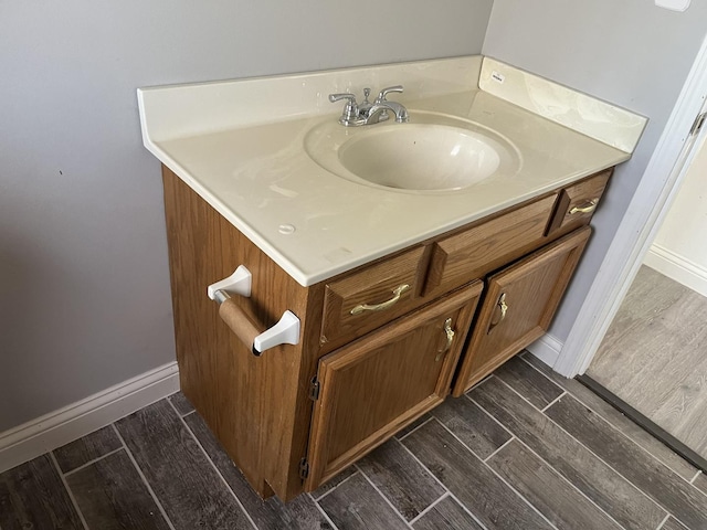 bathroom with vanity, baseboards, and wood finished floors