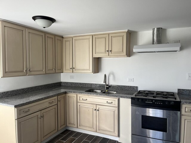 kitchen with a sink, range hood, stainless steel gas range, and dark countertops