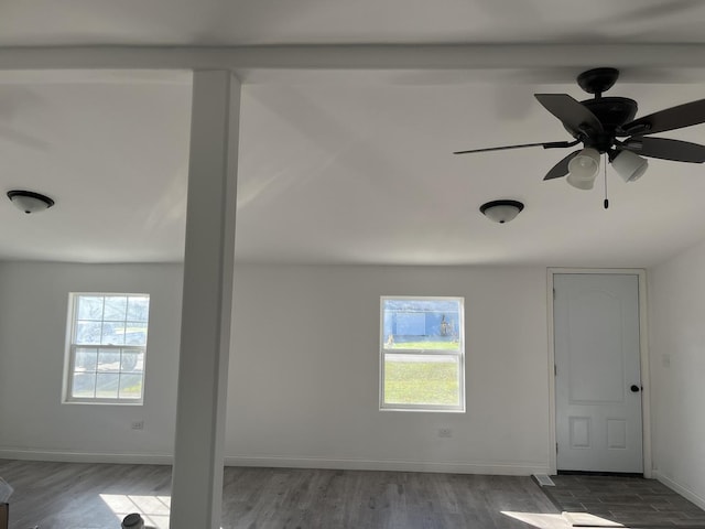 interior space featuring baseboards, a ceiling fan, and wood finished floors