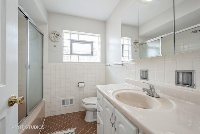 bathroom with visible vents, tile walls, tile patterned floors, vanity, and toilet