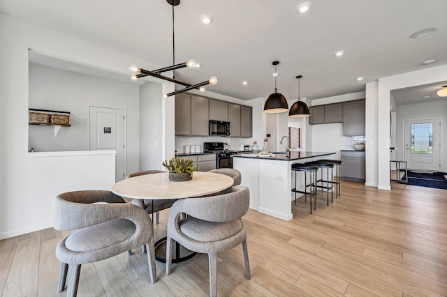 dining area featuring recessed lighting, light wood-style flooring, and baseboards