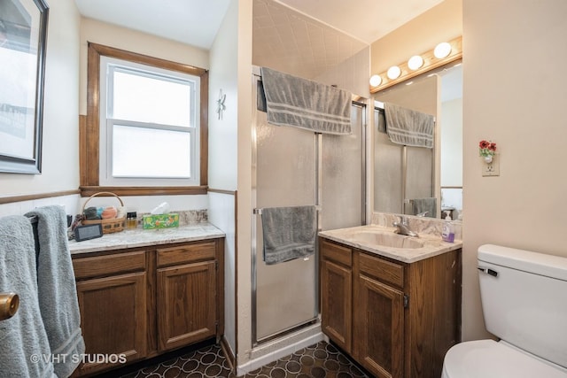 bathroom featuring vanity, a shower stall, and toilet