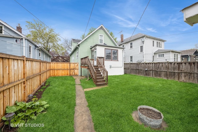 back of house featuring a fenced backyard and a yard
