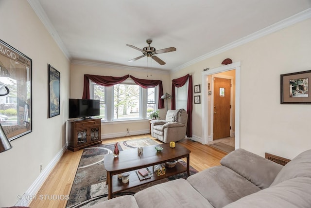 living room with crown molding, ceiling fan, baseboards, and light wood-style floors