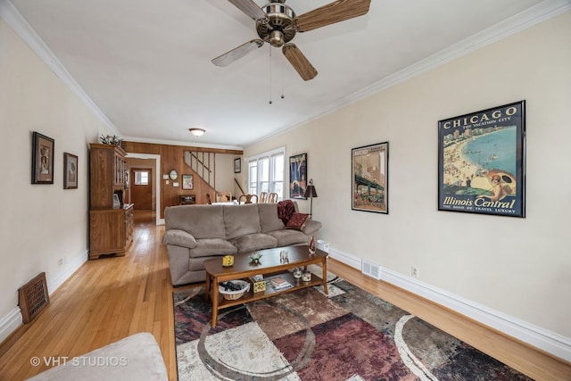 living area with visible vents, ornamental molding, stairway, and light wood-type flooring