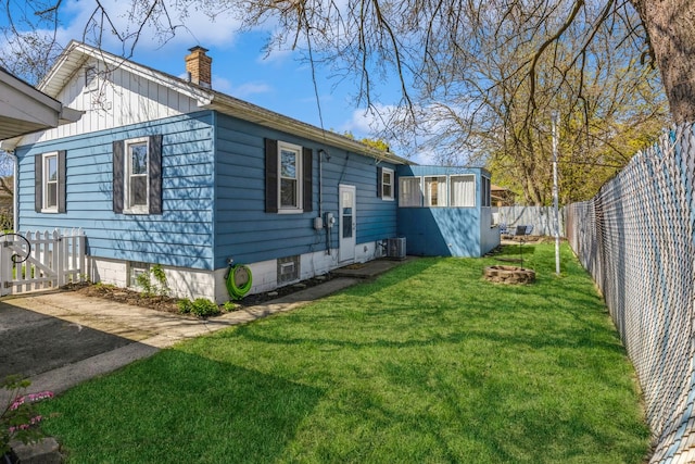 3448 Ann St, Lansing, IL 60438 - view of home's exterior featuring a fenced backyard, a yard, a chimney, and cooling unit