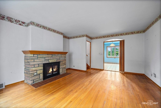 33 Chestnut Ave, Clarendon Hills, IL 60514 - unfurnished living room featuring a fireplace, wood finished floors, baseboards, and arched walkways