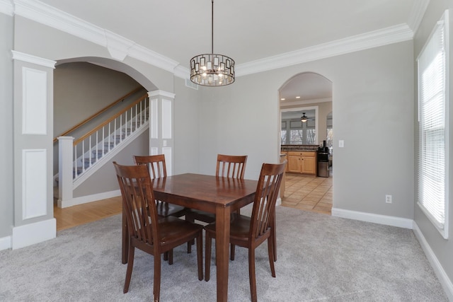 1309 Broad Creek Rd, Bloomington, IL 61704 - dining area with crown molding, arched walkways, and light carpet