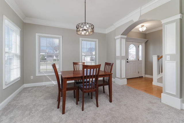 1309 Broad Creek Rd, Bloomington, IL 61704 - dining room featuring light colored carpet, arched walkways, crown molding, and an inviting chandelier