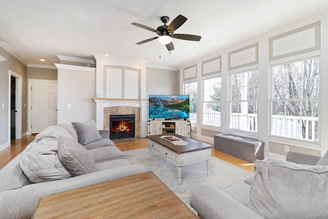 1309 Broad Creek Rd, Bloomington, IL 61704 - living room with a ceiling fan, crown molding, a tile fireplace, baseboards, and light wood finished floors