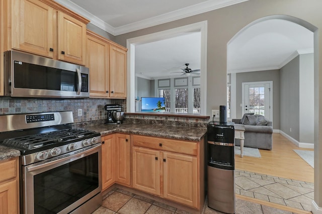 1309 Broad Creek Rd, Bloomington, IL 61704 - kitchen with crown molding, arched walkways, a ceiling fan, backsplash, and stainless steel appliances