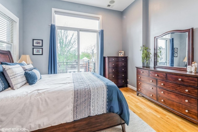 bedroom with baseboards, visible vents, and wood finished floors