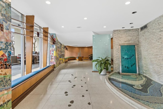 interior space featuring tile patterned flooring, recessed lighting, brick wall, and visible vents