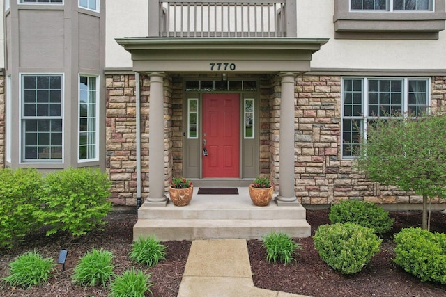7770 Farrell Dr, Lakewood, IL 60014 - property entrance with stone siding, stucco siding, and a balcony