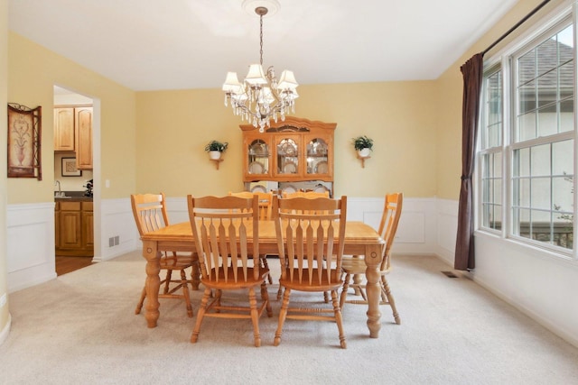 7770 Farrell Dr, Lakewood, IL 60014 - dining area with light carpet, a chandelier, and a wainscoted wall