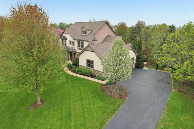 7770 Farrell Dr, Lakewood, IL 60014 - view of front of house featuring stone siding, driveway, a front lawn, stucco siding, and an attached garage