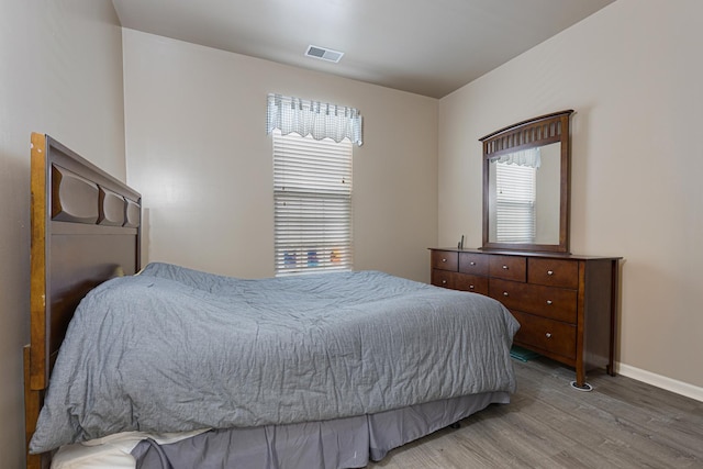 bedroom featuring wood finished floors and baseboards