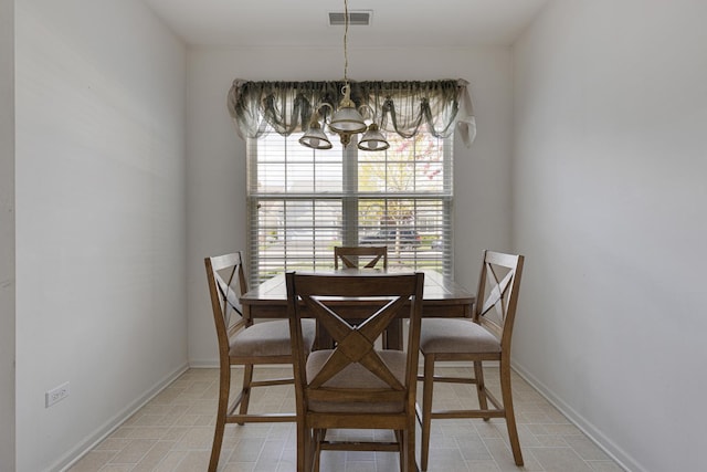 dining space with a chandelier, baseboards, and light tile patterned floors