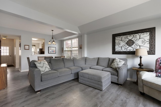 living area with baseboards, wood finished floors, and plenty of natural light