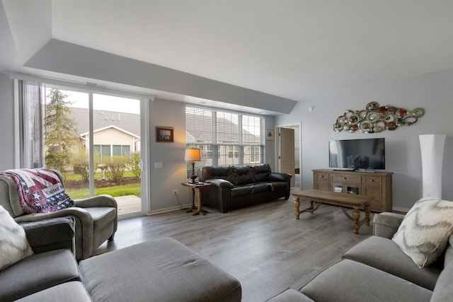 living area with light wood-style flooring and baseboards
