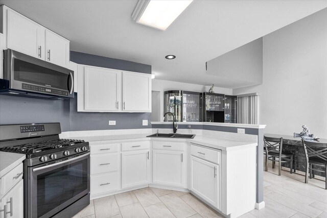 968 N Lancaster Cir S, Elgin, IL 60177 - kitchen with appliances with stainless steel finishes, a sink, light countertops, a peninsula, and white cabinetry