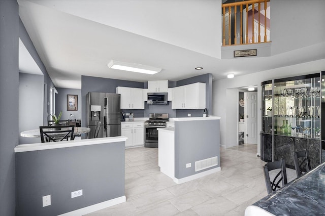 968 N Lancaster Cir S, Elgin, IL 60177 - kitchen featuring visible vents, a peninsula, light countertops, white cabinets, and stainless steel appliances