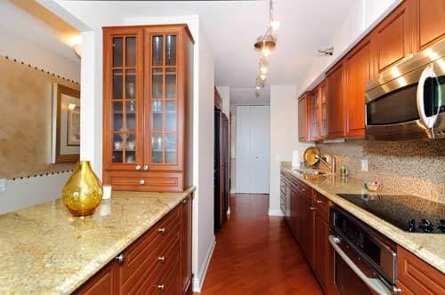 474 N Lake Shore Dr Unit 4808, Chicago, IL 60611 - kitchen with stainless steel appliances, glass insert cabinets, a sink, and tasteful backsplash