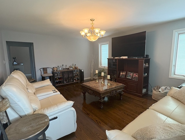 living room with an inviting chandelier, a wealth of natural light, and wood finished floors