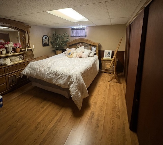 bedroom featuring a paneled ceiling and light wood finished floors