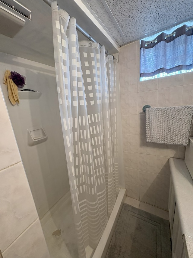 bathroom with tile patterned floors and a shower stall