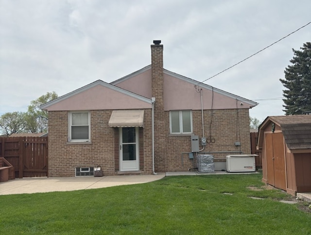 back of property featuring a storage unit, an outdoor structure, brick siding, and a chimney