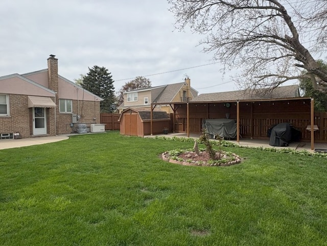 view of yard with a patio area, a shed, and fence